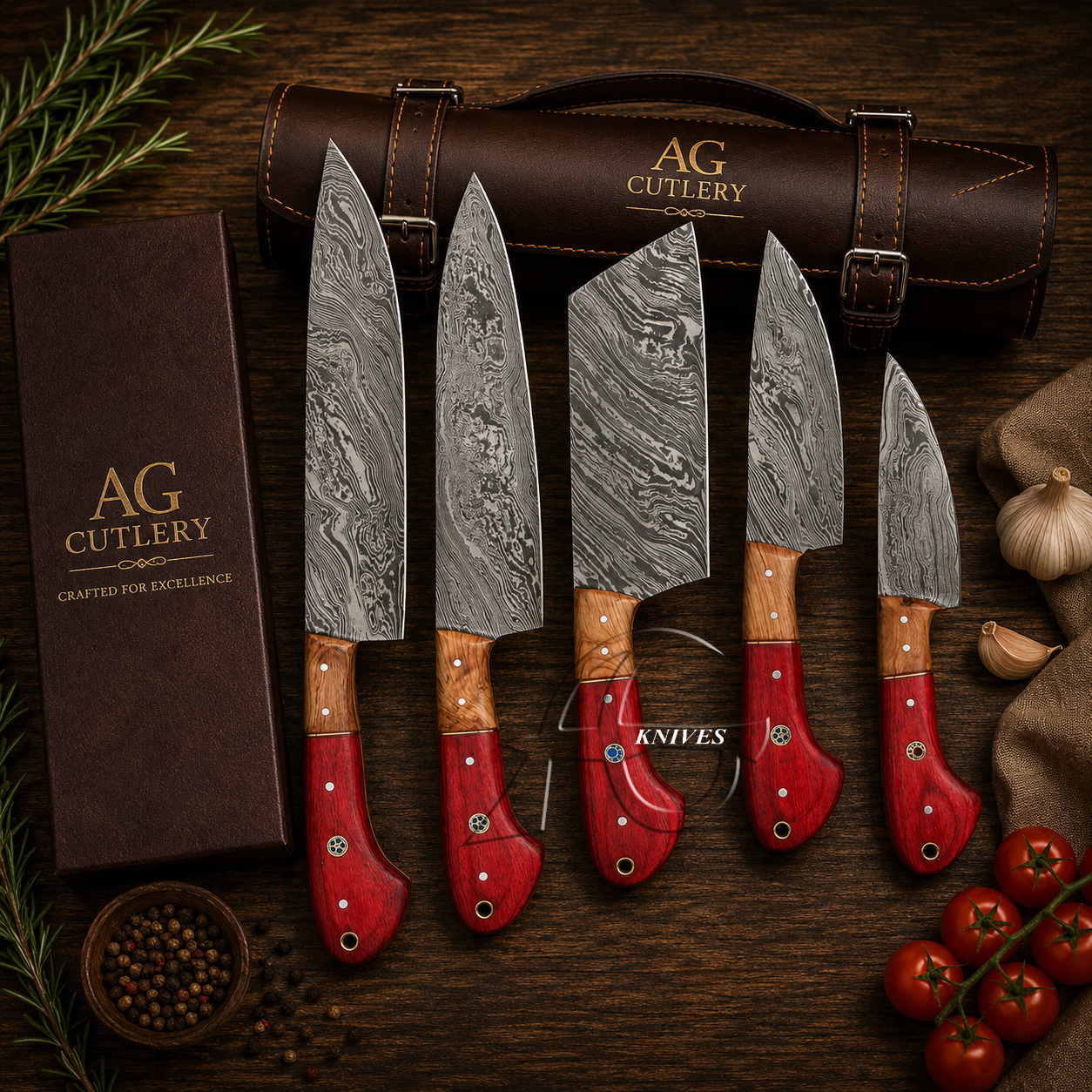 Five AG Cutlery kitchen knives with patterned steel blades and red handles are arranged on a dark wooden surface beside a brown knife case, a branded box, garlic, peppercorns, and tomatoes.