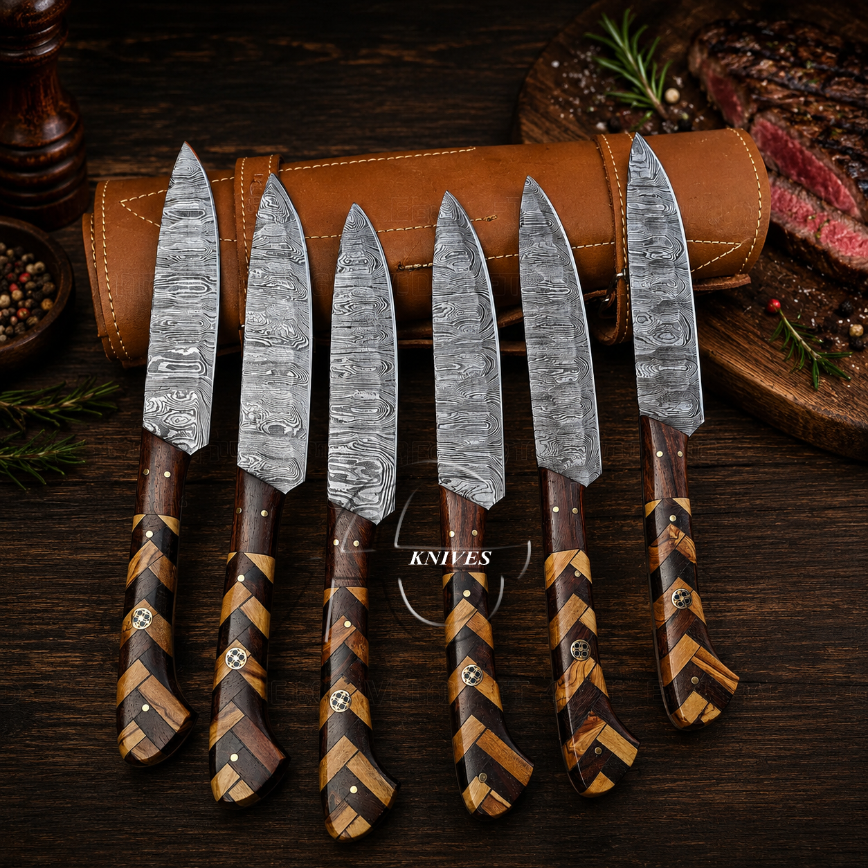 Six kitchen knives with damascus steel blades and brown-and-tan striped wooden handles are arranged in front of a brown leather sheath on a dark wooden table. A cooked steak, peppercorns, and herbs are visible in the background as styled props.