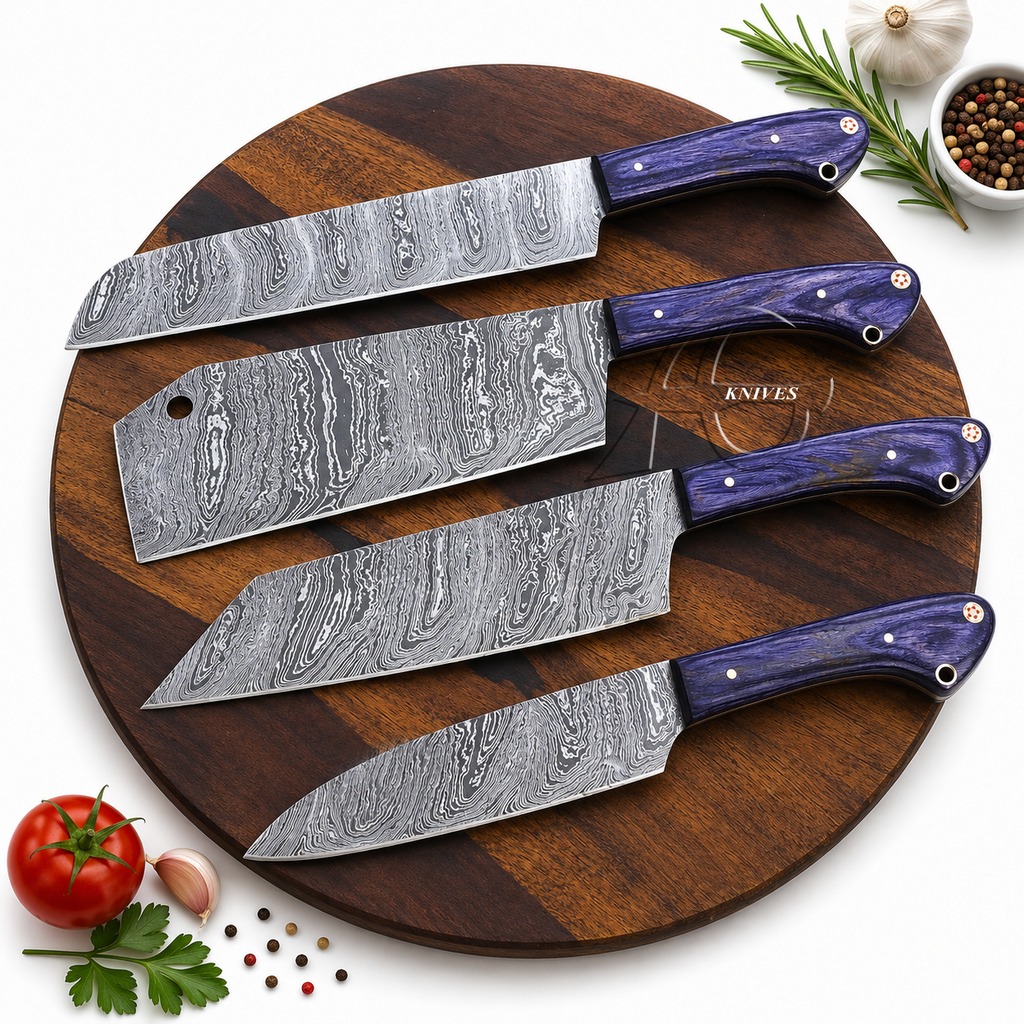 Four kitchen knives with patterned Damascus steel blades and purple handles arranged on a round wooden cutting board, with small food props including a tomato, garlic, parsley, peppercorns, and rosemary around the board.