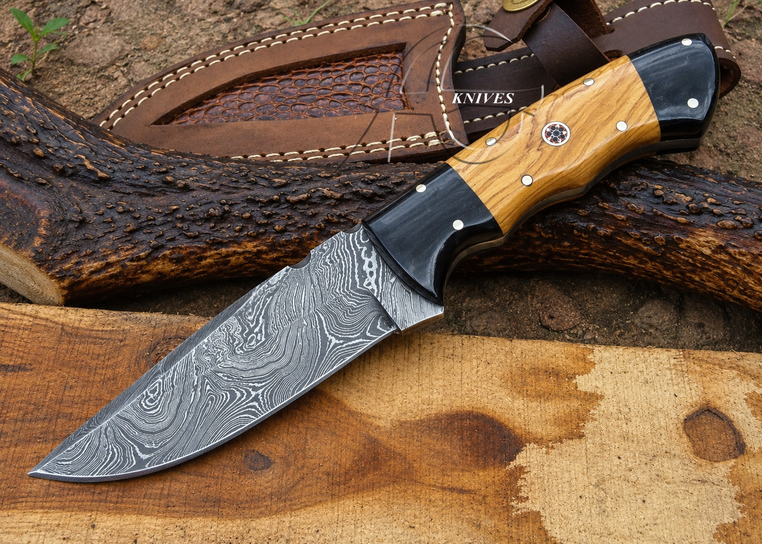 A fixed-blade knife with a patterned Damascus steel blade, a black and wood handle, and a brown leather sheath, displayed on a rustic wood surface.