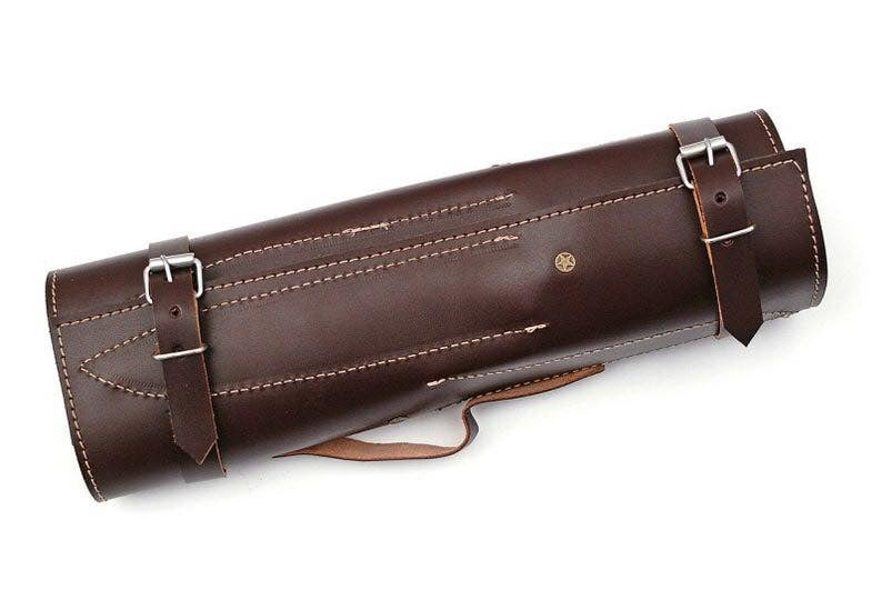 A dark brown leather cylindrical case with adjustable buckle straps and contrast stitching, shown on a plain white background.