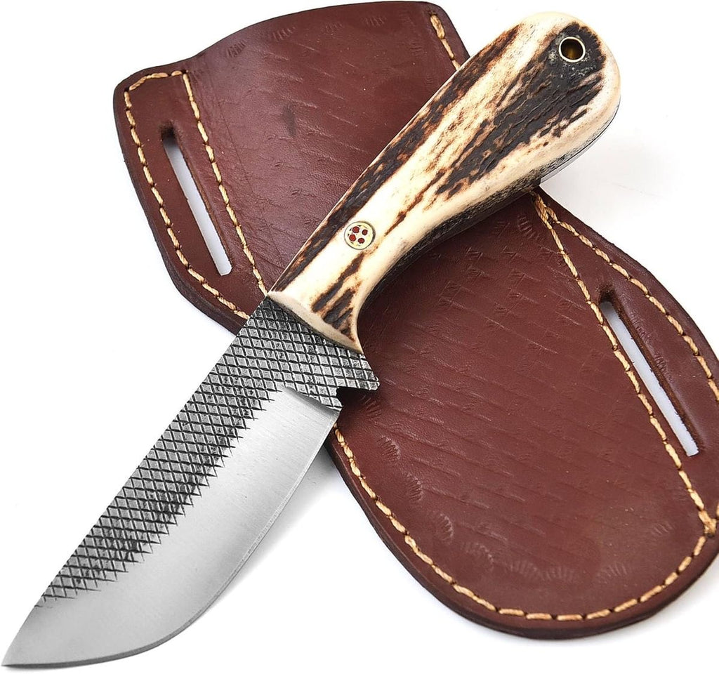 A fixed-blade knife with a textured silver blade and a natural antler-style handle, shown resting on a brown leather sheath against a white background.
